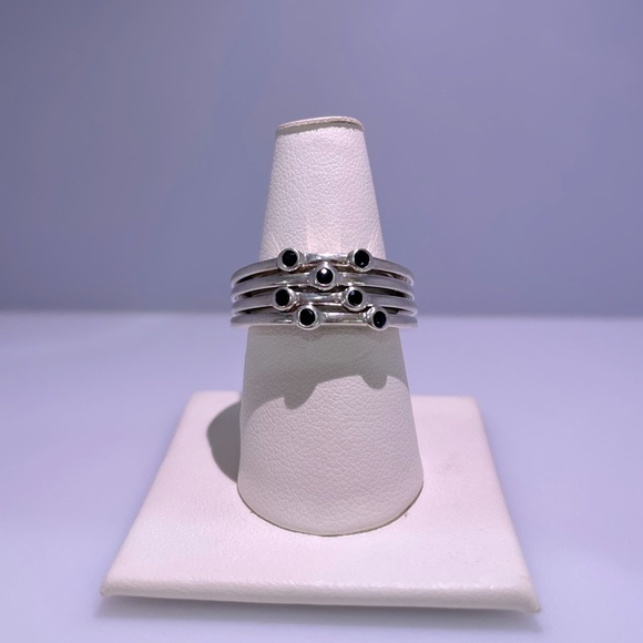 Four Sterling silver ring banded together with blue stones